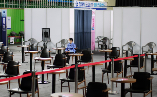 지난 10일 경남 김해시 문화체육관에 마련된 백신접종센터에서 코로나19 백신을 접종한 시민이 이상 반응 여부 확인을 위해 의자에 앉아 있다. <연합뉴스>